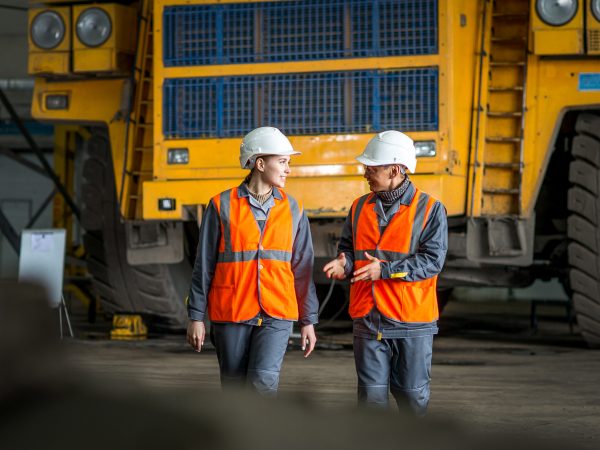 mining workers in front of a huge truck