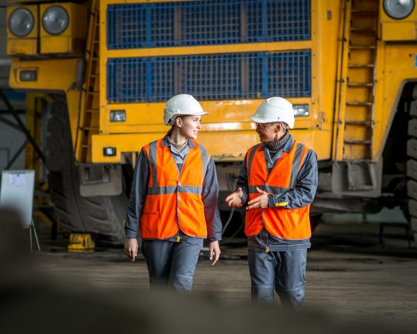 mining workers in front of a huge truck